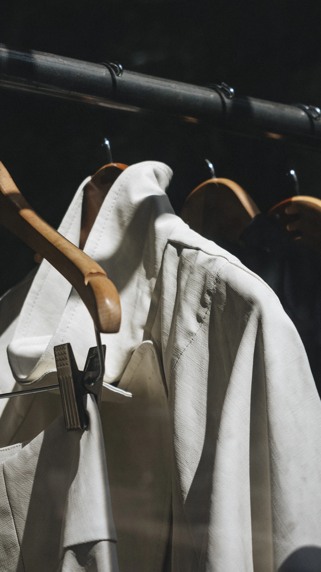 white dress shirt hanged on brown wooden clothes hanger